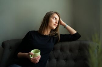 Невыспавшаяся женщина с кофе на диване