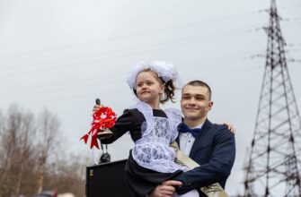 Выпускник держит первоклассницу на руках